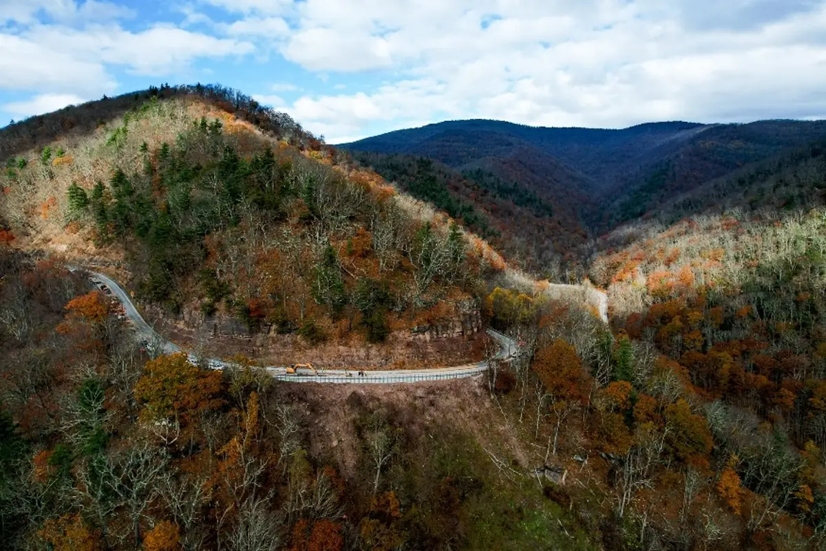 Aerial view of a winding West Virginia mountain highway where the Guardian 5 high-containment barrier protects a steep grade